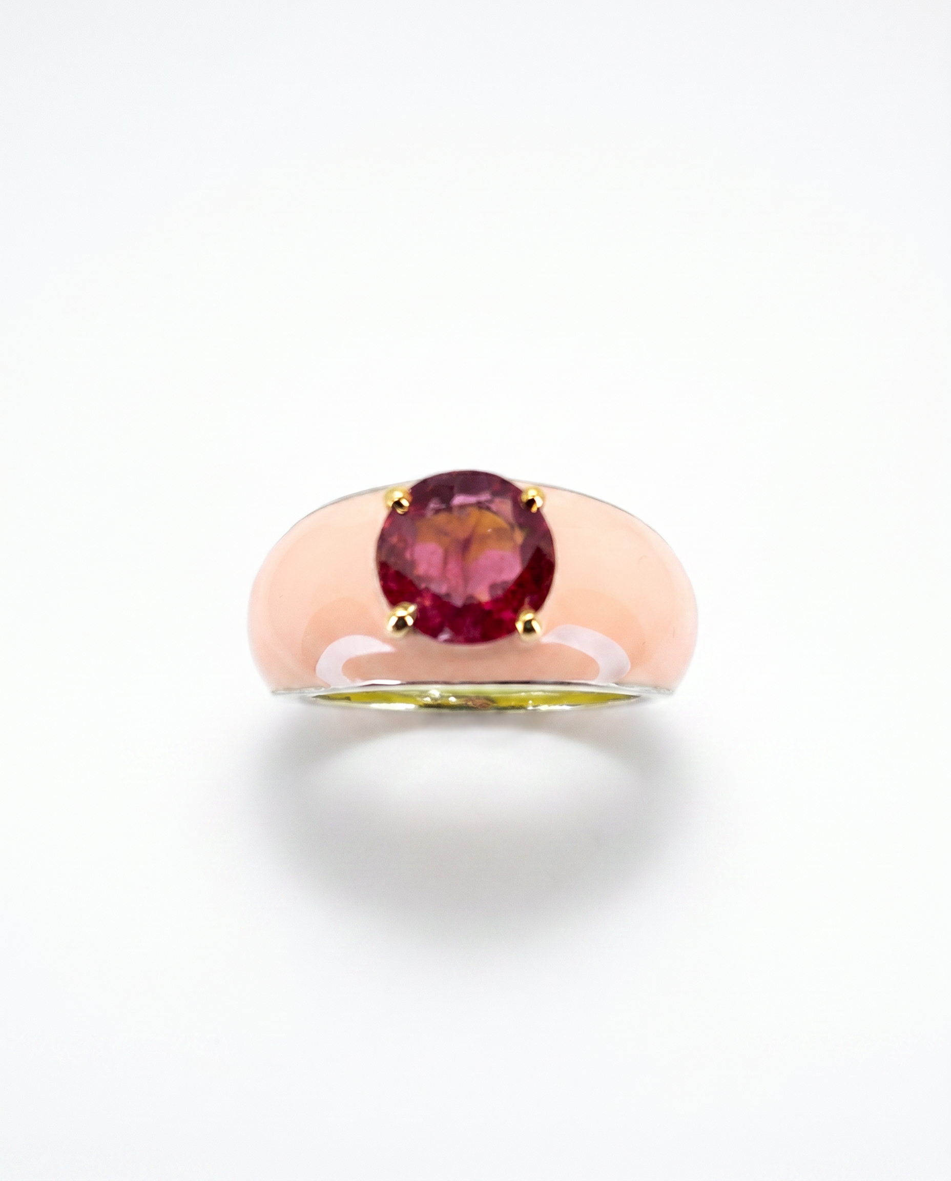 Gold ring with a red gemstone on a white background