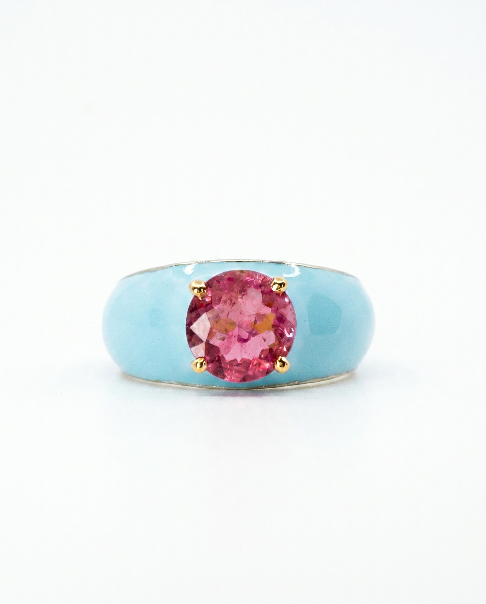 Ring with a pink gemstone and gold accents on a light blue band against a white background