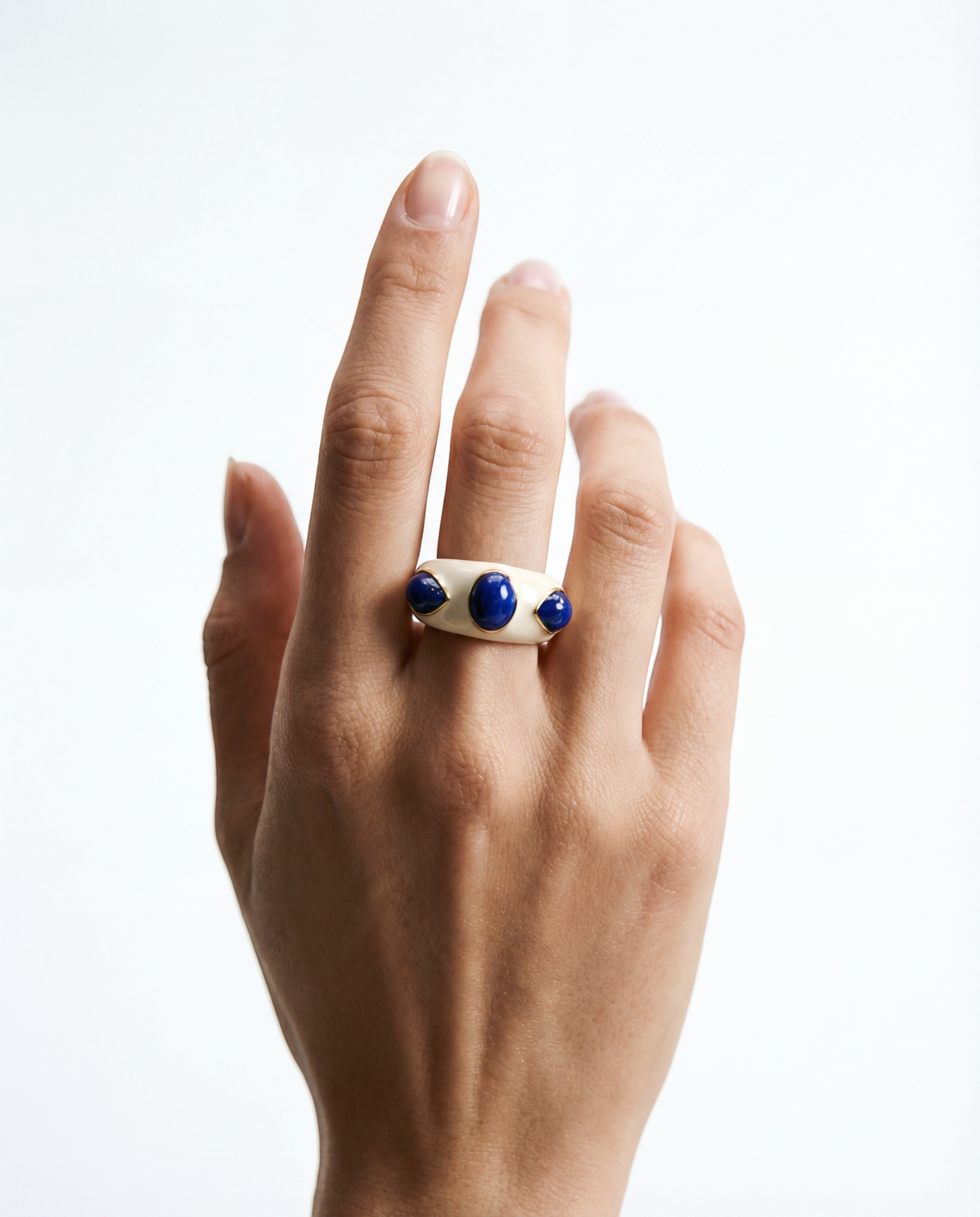 HEILI ROCK Callais ring with a cream enamel band and three blue lapis lazuli cabochon gemstones.